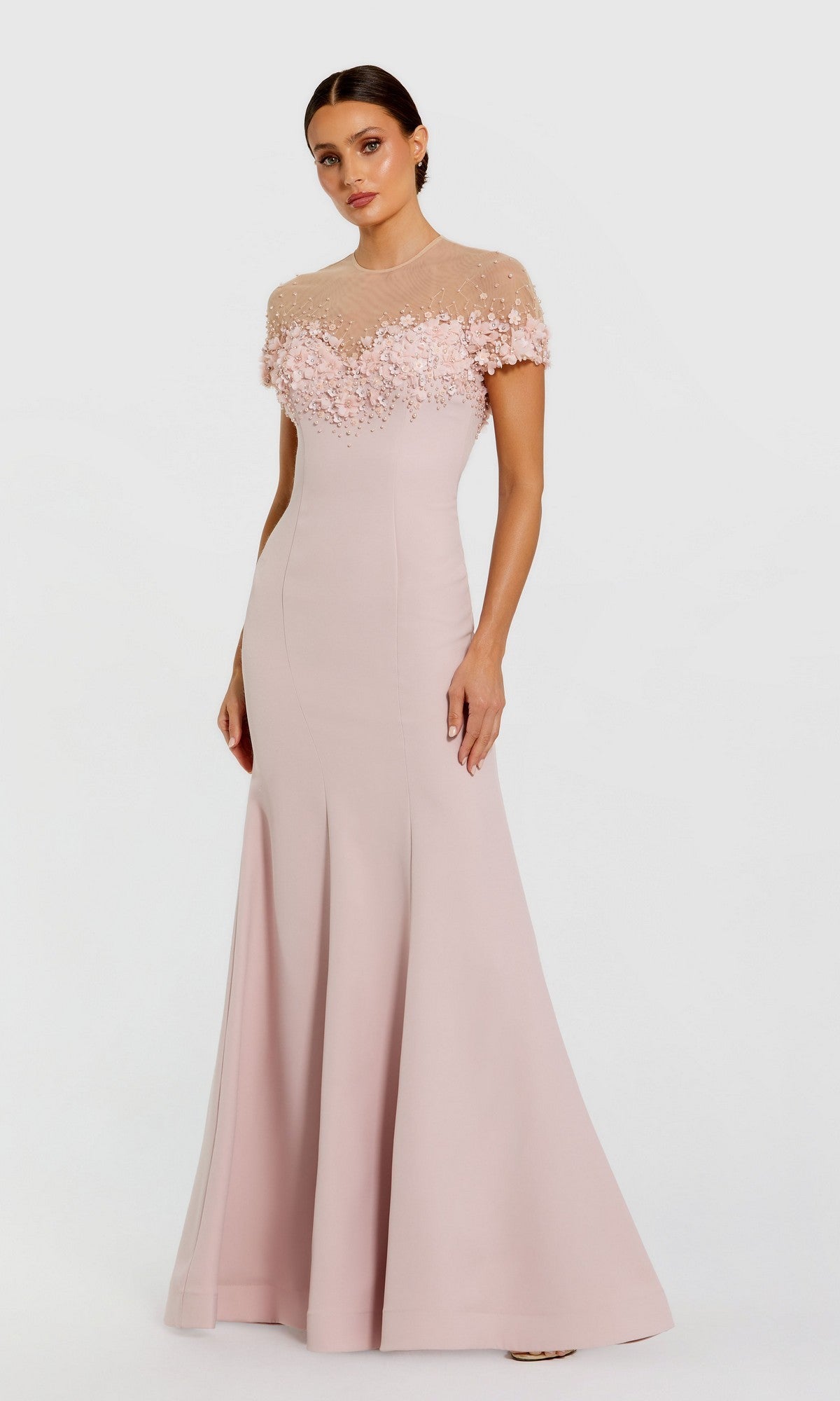 A woman poses gracefully against a white background in the Mac Duggal 11867 long formal dress, featuring mauve fabric, floral embellishments, and a beaded illusion neckline.